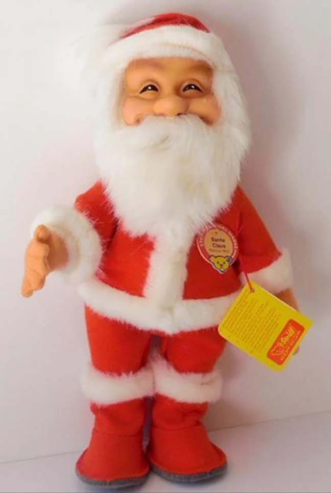 A cheerful Steiff Santa Claus doll dressed in a red felt suit with white mohair trim, featuring a smiling rubber face, white beard, and Steiff tag attached to the chest.